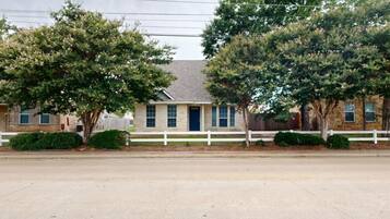 A two-story house with a white picket fence, a front door, and a garage.