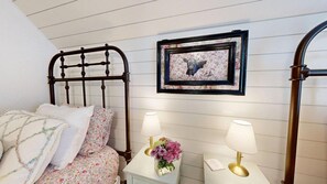 A bedroom with a bed, nightstands, a framed picture, and a lamp. - Central Cottage Charm - Pet Friendly! Very Clean! (College Station)