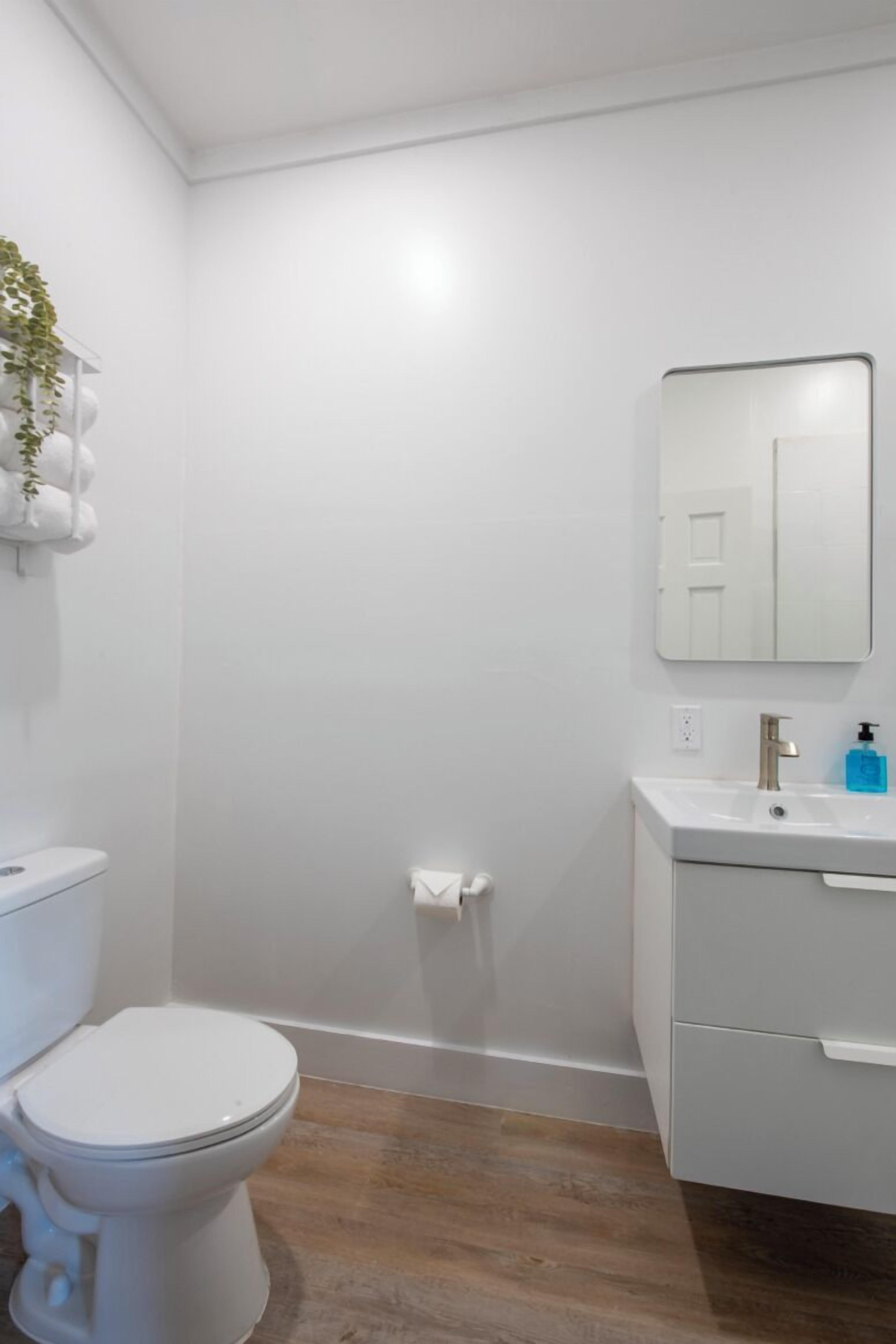 Un baño con inodoro, lavamanos y espejo.