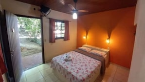A bedroom with a bed, a ceiling fan, a window with curtains, and a door leading outside. - A Casa do Pablo (Buzios)