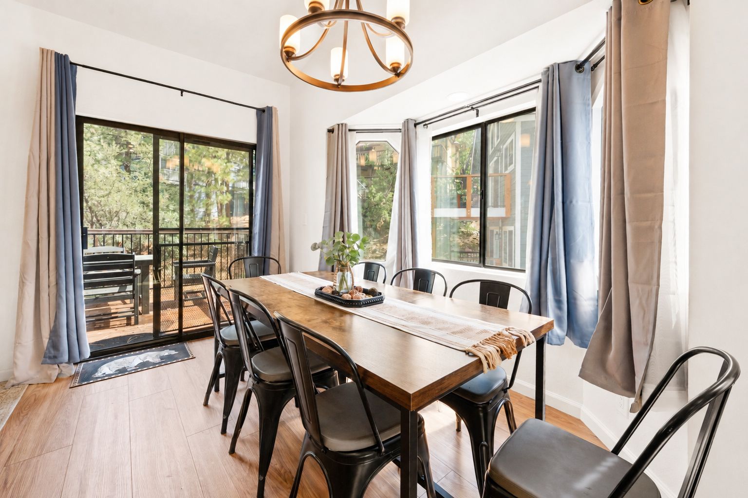 A dining area with a wooden table, black chairs, and a chandelier.