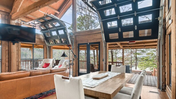 A wooden interior with a sofa, dining table, and chairs.