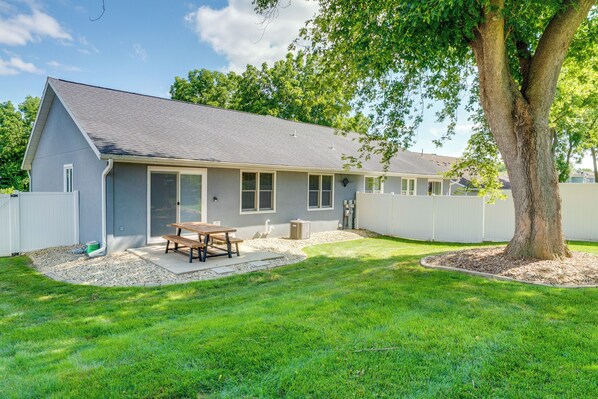 A two-story house with a covered patio, a large tree, and a well-maintained lawn. - 1 Mi to Beach: Dog-Friendly Condo in Lake Mills! (Lake Mills)