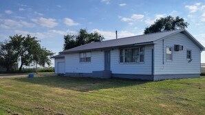 A single-story house with a gabled roof, a front door, and a small porch. - Peaceful Nostalgic Farmhouse (Plankinton)