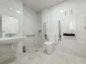 A modern bathroom with a sink, toilet, and shower.