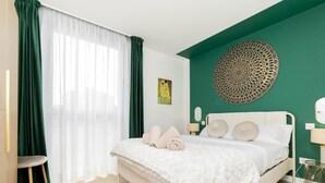 A bedroom with a bed, a chair, a lamp, and a wall decoration. - Aurora Stays by Charming IV, Apartment for 4 with free parking (Madrid)