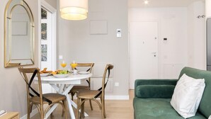 A modern living room with a green sofa, a dining table with chairs, and a pendant light. - Aurora Stays by Charming IV, Apartment for 4 with free parking (Madrid)
