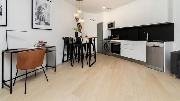 Una cocina moderna con comedor, lavadora y refrigerador.