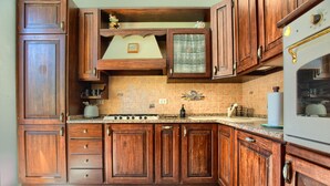 Une cuisine avec des meubles en bois, une cuisinière et un dosseret carrelé.