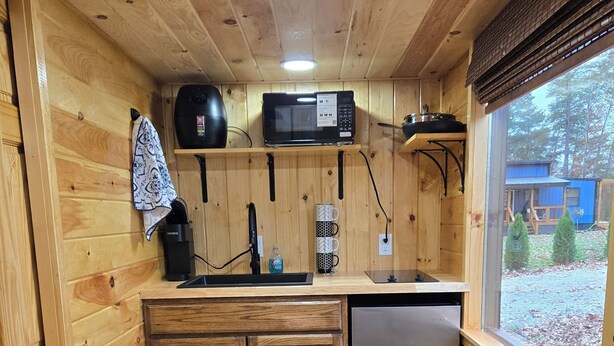 A compact wooden kitchen with a microwave, coffee maker, and a sink. - Pet friendly fenced yard, 2 tiny homes rented as one close to Fall Creek Falls (Sparta)