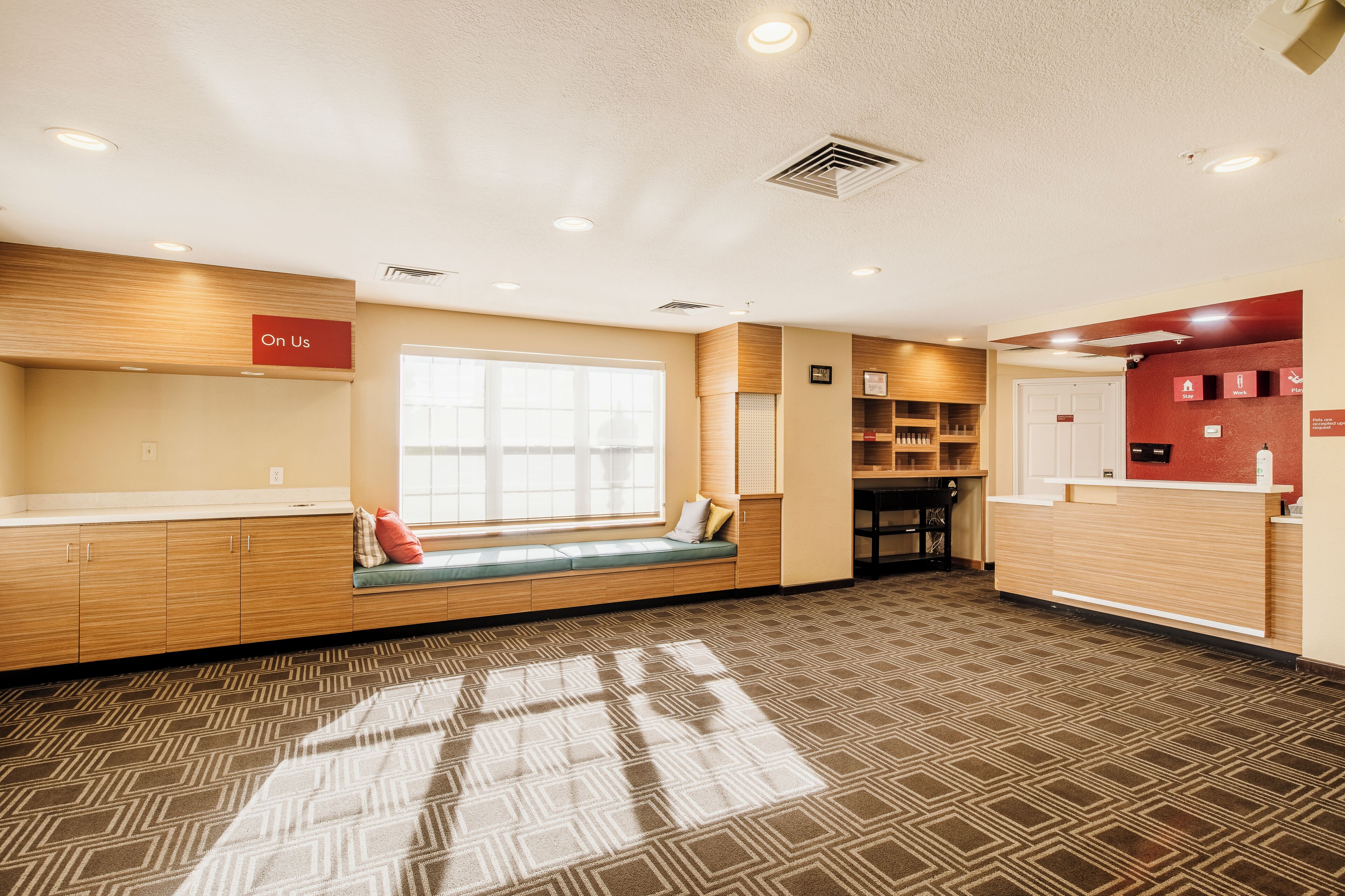 A reception area with a wooden bench, a large window, and a reception desk.