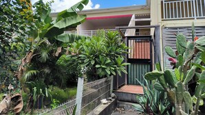 A residential area with a gated entrance, a balcony, and various plants. - Charming T3 apartment in Le Diamant (Le Diamant)