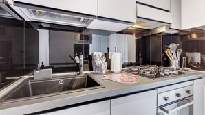 A modern kitchen with a stainless steel sink, a microwave, and a gas stove.