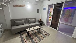 Una sala de estar moderna con un sofá gris, una mesa de centro y una alfombra estampada.