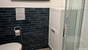 Ein Badezimmer mit Toilette, Bidet und einer Duschkabine aus Glas.