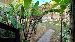 A garden pathway leading to a patio area with outdoor seating. - Tatu Do Bem Hospedagem (Serra)