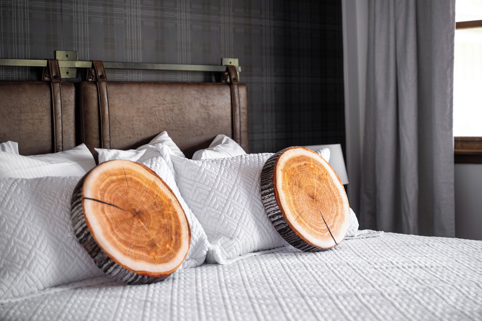 A bed with a headboard, pillows, and a blanket.