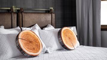 A bed with a headboard, pillows, and a blanket.