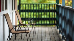 A porch with chairs and a railing. - Lumberjill Lodge (Balsam Lake)