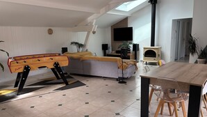 A modern living room with a sofa, a coffee table, a dining table, and a foosball table. - Family home, Seignosse bourg (Seignosse)