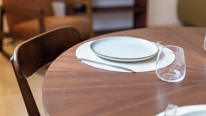 A dining table with plates and cutlery, a chair, and a lamp in the background. - Hygge Living Lisbon-Belém Long Stay (Lisboa)