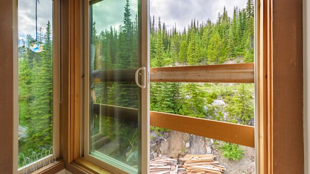 A room with a large window overlooking a forested area.