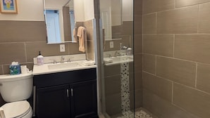 Une salle de bain moderne équipée de toilettes, d’un lavabo et d’une douche.