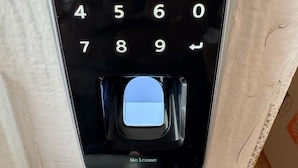 Un clavier à code avec une étiquette indiquant « Bienvenue », un pavé numérique et un bouton bleu.