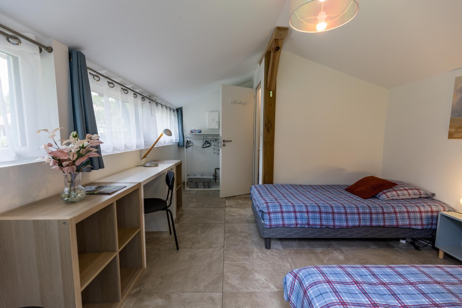 A compact room with a bed, a desk, and a chair.