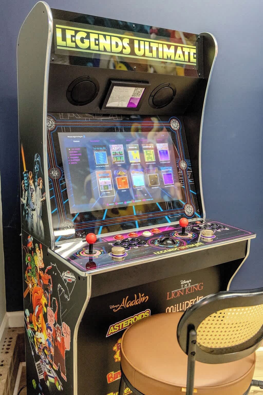 An arcade machine titled "Legends Ultimate" with a screen displaying game options, a joystick, and buttons.