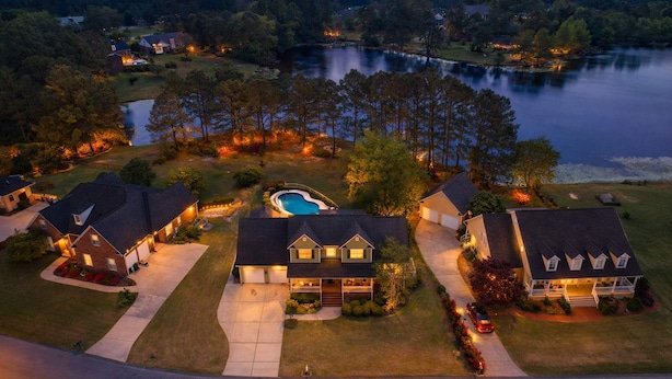 A residential area with houses, a swimming pool, and a lake.
