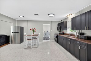 Una cocina moderna con refrigerador, estufa y gabinetes oscuros.