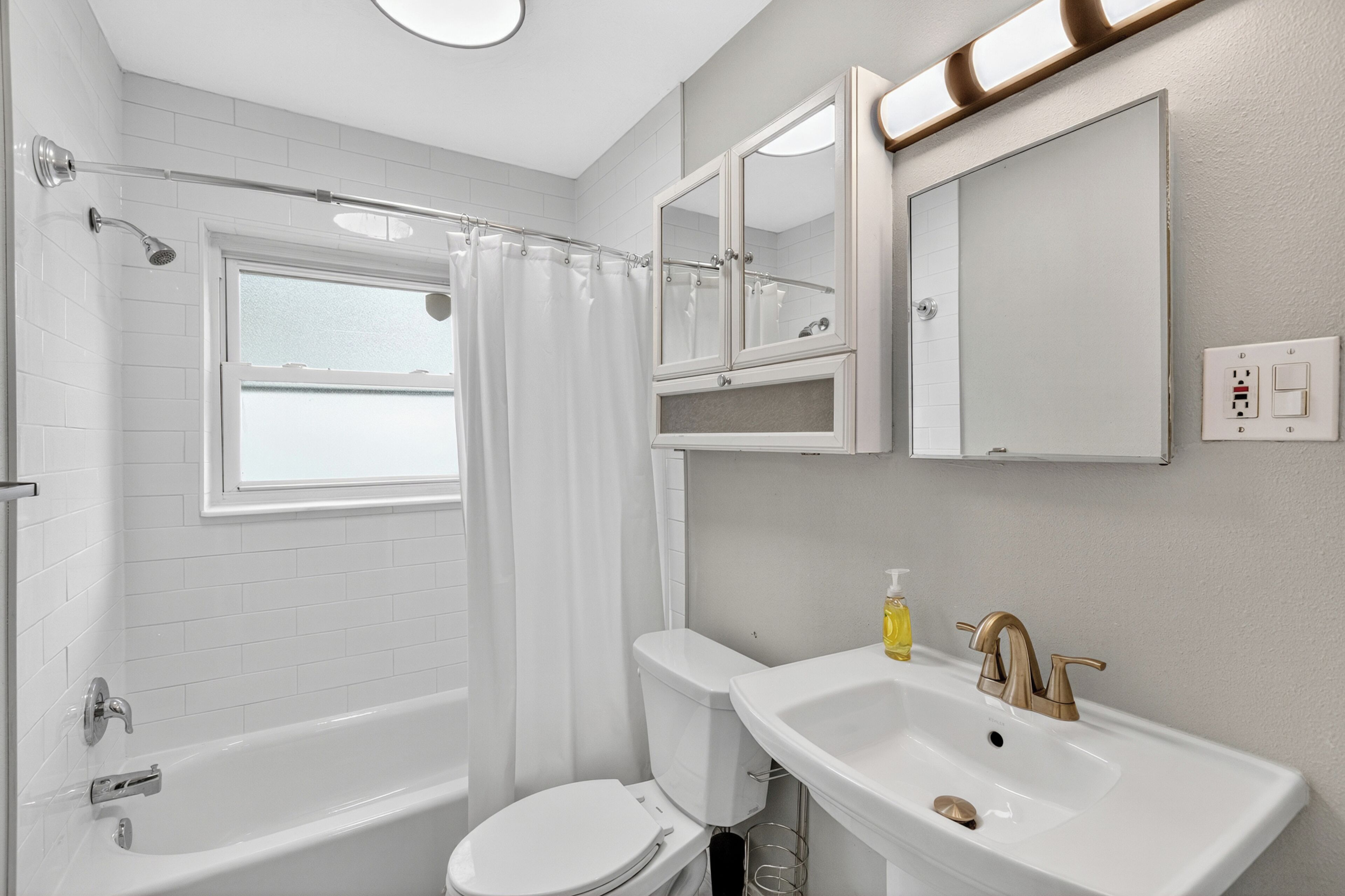 A modern bathroom with a bathtub, toilet, and sink.