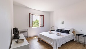 A bedroom with a bed, a desk, a window, and a sculpture. - Appartement Prunelle - Welkeys (Soorts-Hossegor)