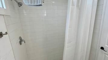 Een douche, handdoeken, zeep, shampoo