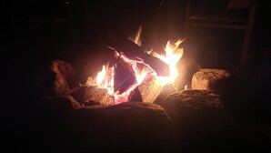 Primer pla d'un foc cremant en una llar de foc, amb llenya i flames.