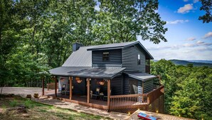 Une cabane dotée d’une véranda, d’une terrasse et d’un petit jardin.