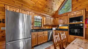 Une cuisine de style rustique, avec des meubles en bois, un réfrigérateur en acier inoxydable, un lave-vaisselle et une cuisinière.