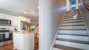 Una cocina moderna con muebles blancos, electrodomésticos de acero inoxidable y una isla de madera.