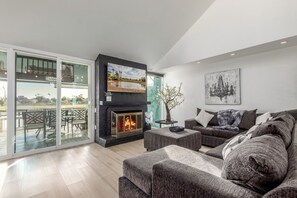 TV connectée, cheminée, livres, écrans d'ordinateur