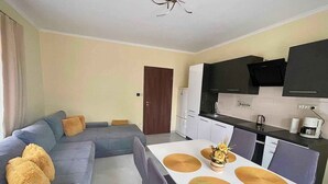 A modern apartment with a living area, dining space, and kitchen.