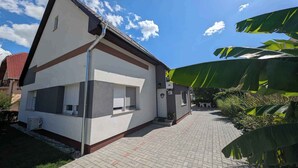 A two-story house with a paved driveway and a small garden area.