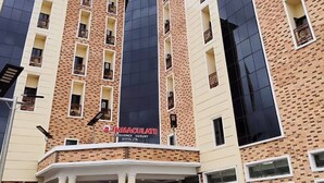 Ein mehrstöckiges Hotel mit Ziegelverkleidung, großen Fenstern und einem markanten Eingangsbereich mit weißem Baldachin.