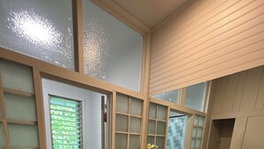 Een moderne badkamer met een houten vloer, een beige wastafel en een grote spiegel.