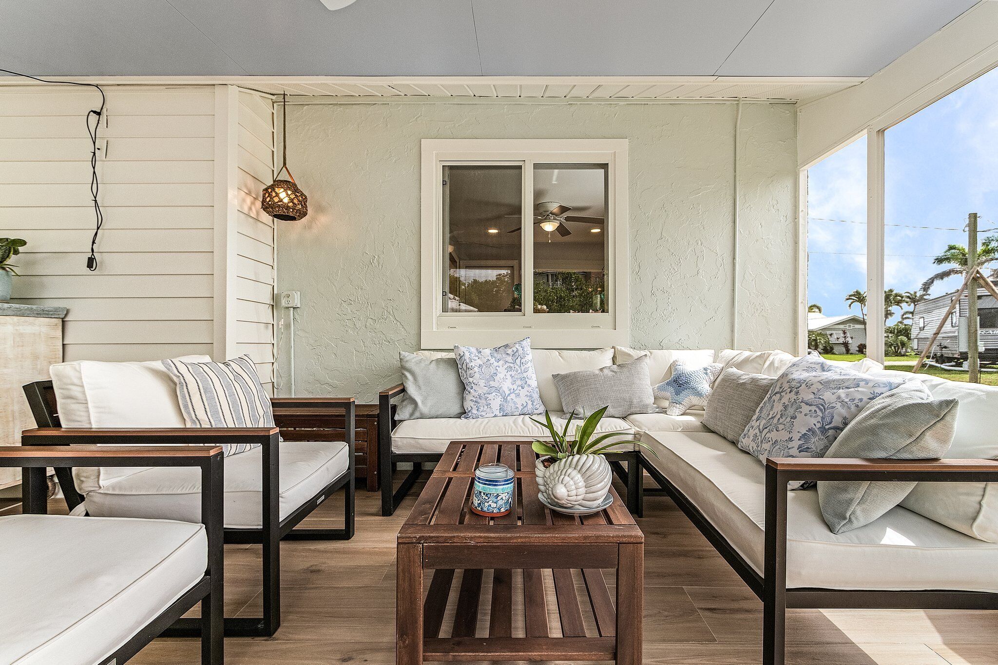 A cozy living room with a sofa, chairs, and a coffee table. There is a window with a view of the outdoors.