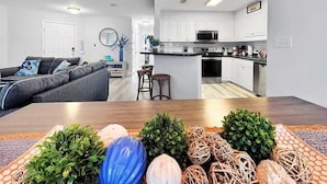 A modern living room with a sofa and a dining table with decorative items.