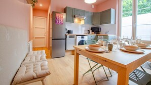 A compact kitchen with a dining area, a bench, and a window providing natural light.