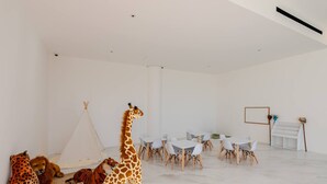 A room with a white interior, a dining area with white chairs and a table, and a white floor. - Brand new San Jose Condo (San José del Cabo)