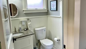 A bathroom with a toilet, sink, and window. - Quaint Historical Southtown - La Casita on Simon (San Antonio)