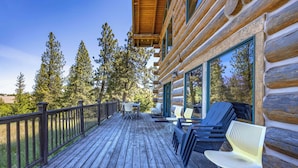 Une terrasse en bois avec des sièges extérieurs et une vue sur les arbres.